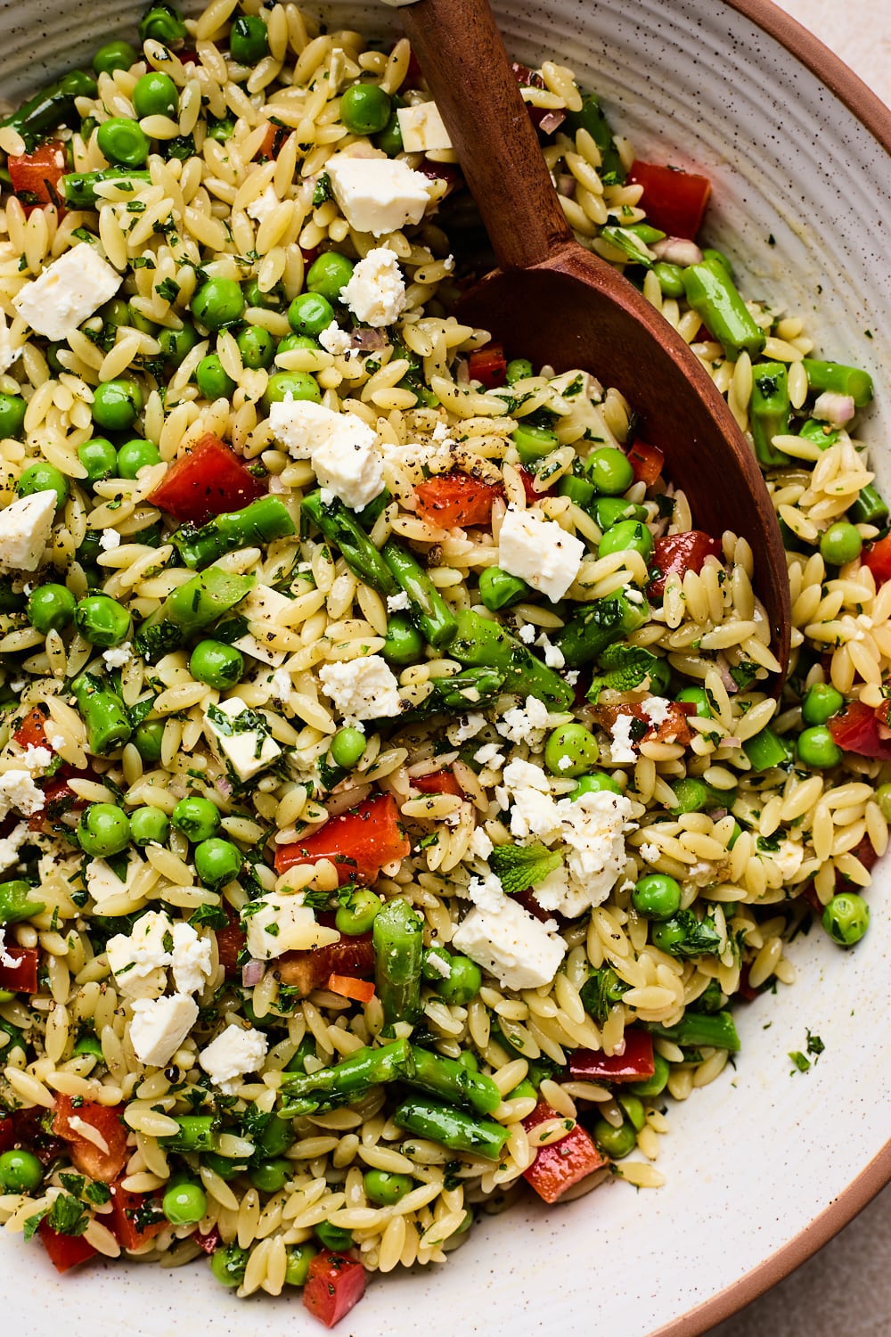 Orzo Pasta Salad being served in a bowl with a spoon